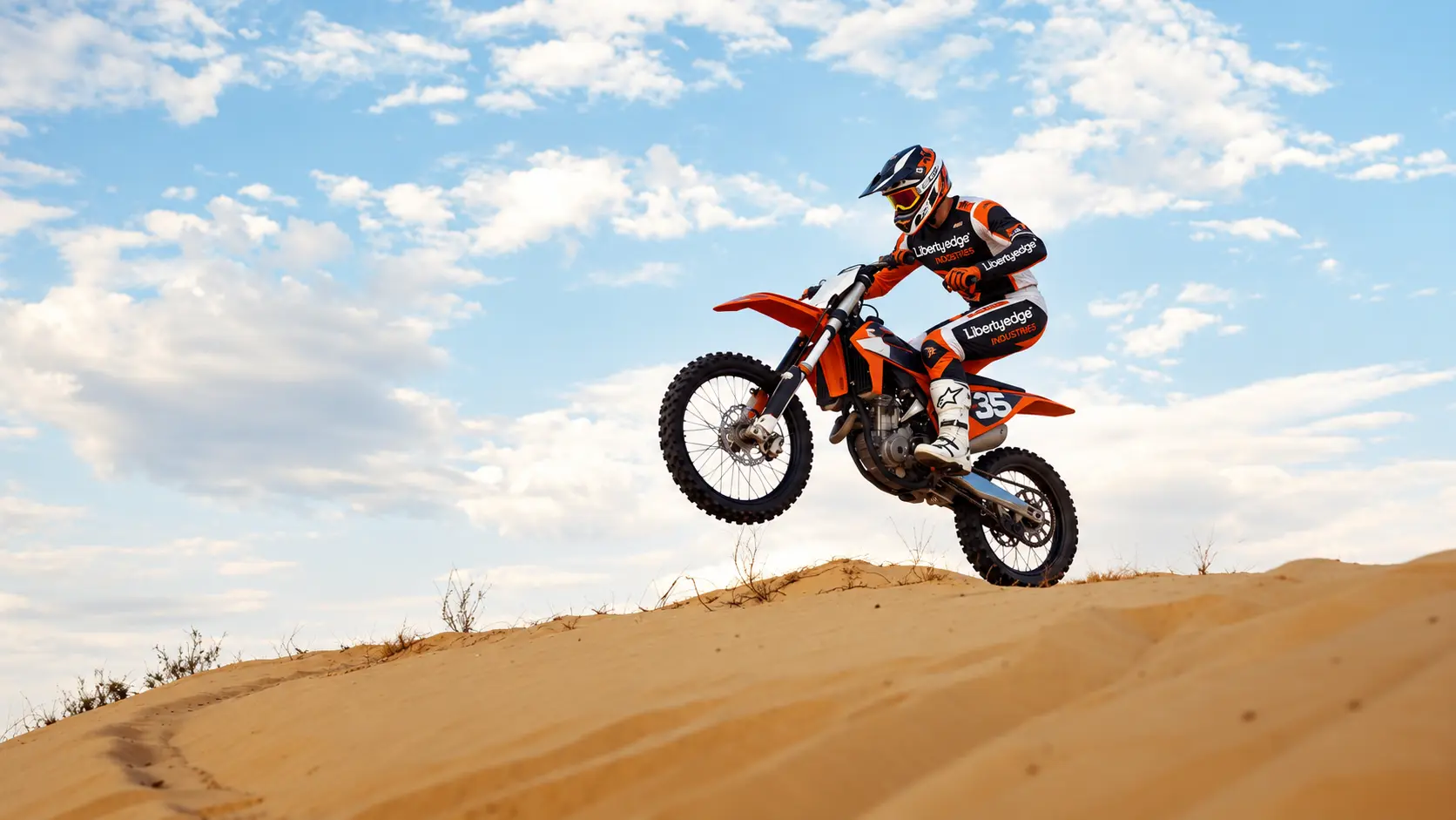Motocross rider in Liberty Edge apparel launching over a dirt track